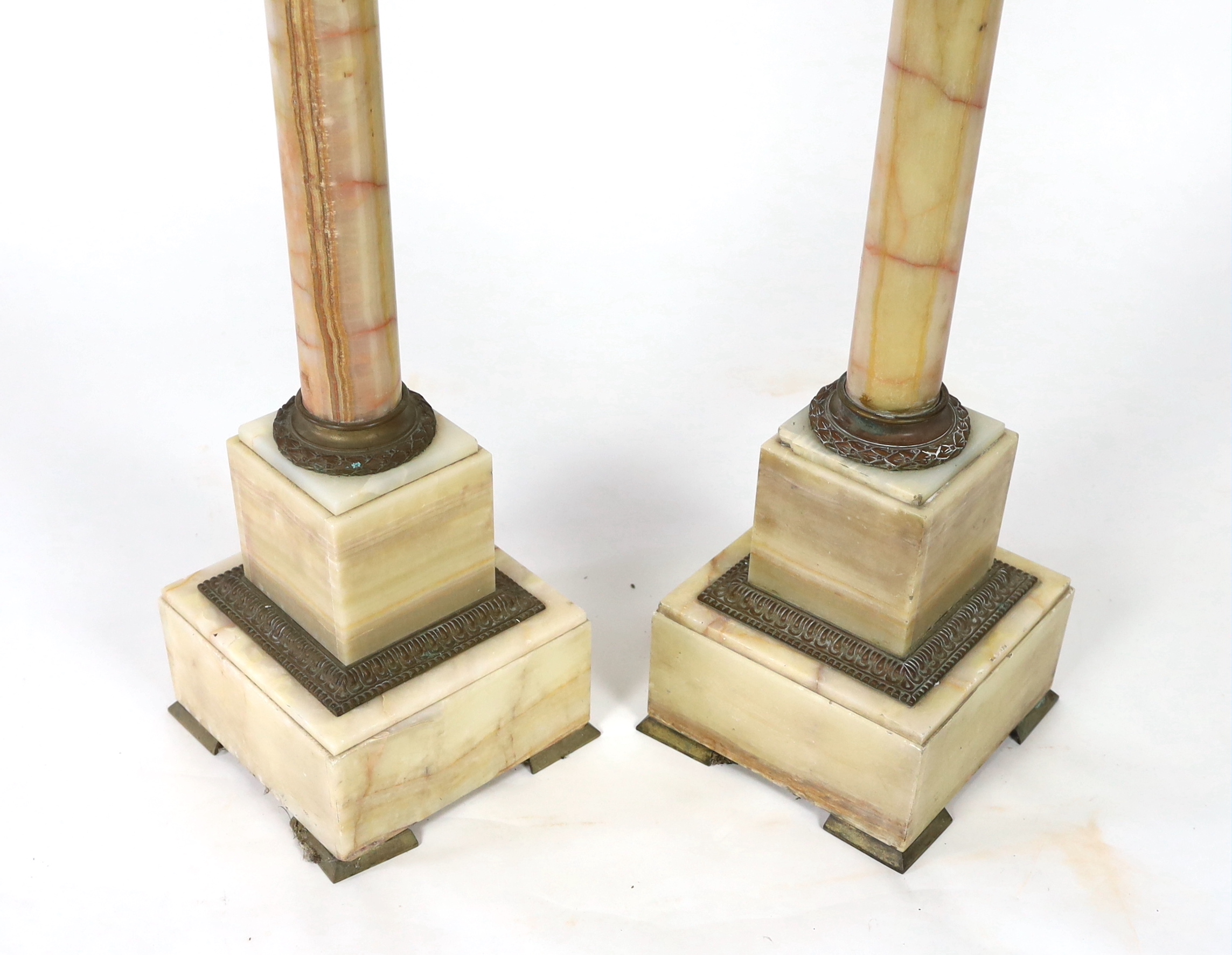 A pair of early 20th century French ormolu mounted onyx pedestals, width 25cm, height 99cm